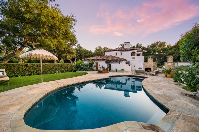 Casa con piscina trasera con atardecer
